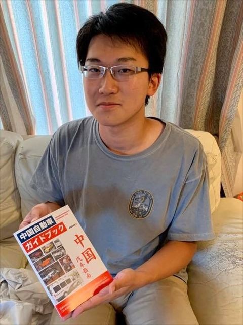 自身で制作した「中国自動車ガイドブック」を手にする博人さん