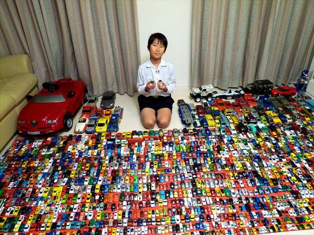 ミニカーに囲まれた小学生の博人さん