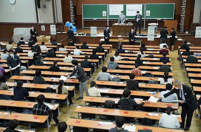 大学入学共通テストで英語の試験開始を待つ受験生たち。席の間には赤い×印が付けられていた=2021年1月、東京都文京区の東京大、鬼室黎撮影