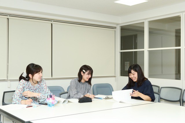 学生寮のラウンジで後輩たちと語り合う4年生の小林茉莉子さん(右)